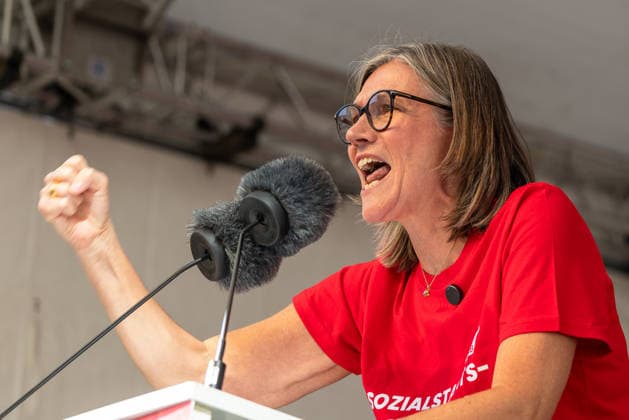 DGB Bavaria: Hard Earned Mass Rally, Nuremberg, September 26, 2026 Christiane Benner, President of IG Metall, speaks into the microphone at a rally with her fist raised and a passionate expression. The speaker is wearing a red T-shirt with the words Sozialstaats and appears determined and energetic. Nuremberg, Bavaria, Germany 20260926-1V9A9858-M4000