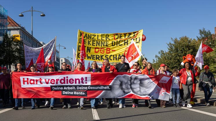 DGB Bavaria Hard-Earned Mass Rally, Nuremberg, September 26, 2026 Protest march along Frauentorgraben to the DGB’s Hard-Earned rally, led by a large red banner featuring a fist symbol. In the middle of the front row, Christiane Benner, President of IG Metall, walks with focus and determination among other participants. Nuremberg, Bavaria, Germany 20260926-286A9146-M4000