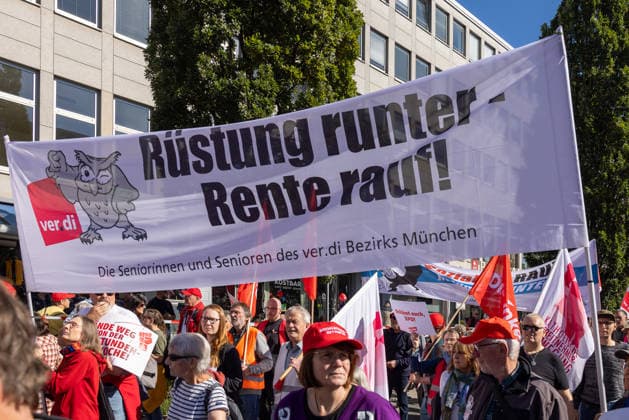 DGB Bavaria: Hard Work, Big Pay Mass Rally, Nuremberg, September 26, 2026: Senior members of the ver.di Munich district carry a banner reading Cut military spending, raise pensions through the crowd. Bystanders and demonstrators hold additional flags and posters. Nuremberg, Bavaria, Germany 20260926-286A9160-M4000
