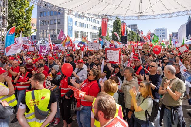 DGB Bavaria Hard-Earned Rally, Nuremberg, September 26, 2026 Numerous participants in the DGB rally Hard-Earned gather at the Kornmarkt with red flags, high-visibility vests, and posters. Several people applaud and chant with their hands raised; a woman holds a red balloon in front of her face. Nuremberg, Bavaria, Germany 20260926-286A9220-M4000