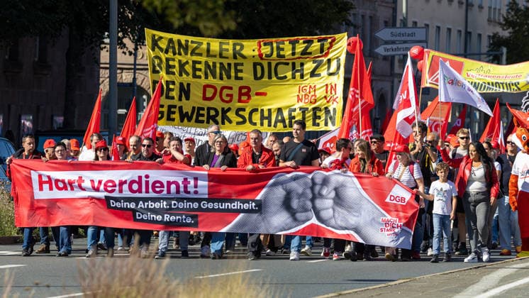 DGB Bavaria Hardly Earned Large Rally, Nuremberg, September 26, 2026 A DGB demonstration march winds through the streets along Frauentorgraben, led by participants carrying a large banner reading Hardly Earned. Walking in the middle is Christiane Benner, President of IG Metall, surrounded by numerous participants carrying red flags and posters. Nuremberg, Bavaria 20260926-1V9A9691-M4000