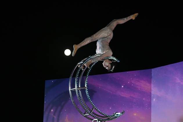RECORD DATE NOT STATED Hong Kong daily life A performer executes a tumbling routine on a circular apparatus during a nighttime event and a moon is visible in the sky in Hung Hom New Waterfront the day after the Mid-Autumn Festival on September 26, 2026 in Hong Kong. (Photo by Kobe Li Nexpher Images) Hong Kong