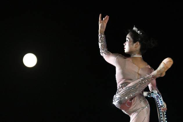 RECORD DATE NOT STATED Hong Kong daily life A performer executes a tumbling routine on a circular apparatus during a nighttime event and a moon is visible in the sky in Hung Hom New Waterfront the day after the Mid-Autumn Festival on September 26, 2026 in Hong Kong. (Photo by Kobe Li Nexpher Images) Hong Kong