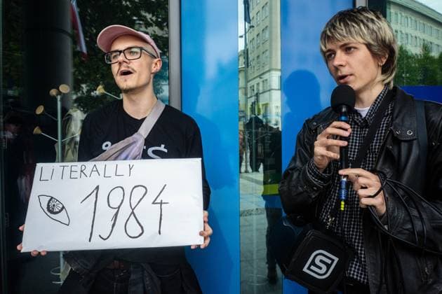 September 26, 2026, Warsaw, Mazovia, Poland: A protester speaks through a microphone while another holds a placard..Left-wing antifascist activists gather outside the European Union Commission building in Warsaw to protest against the Chat Control 1.0 legislation recently revived by the European Parliament. The legislation allows for the mass scanning of messages belonging to every European Union citizen for Child Sexual Abuse Material (CSAM) in the name of protecting children s rights and combating pedophilia. The activists, however, believe rights to privacy and the foundations of free speech are being trampled upon, especially with talks due to resume regarding the far more dangerous Chat Control 2.0 bill, which aims to read even ful  - ZUMAs197 20260926_aaa_s197_190 Copyright: xNeilxMiltonx
