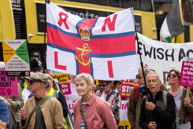 September 26, 2026, Manchester, United Kingdom: Protesters hold a banner with RNLI (Royal National Lifeboat Institution) during the rally. Activists in Manchester march for Stand Up To Racism against the far right. In addition to anti-racist slogans promoting diversity and migrant rights, demonstrators carried banners of the RNLI (Royal National Lifeboat Institution) following recent Patriot Platform protests. The broad coalition of trade unions, community groups, and political organisations featured prominent banners from BECTU (Broadcasting, Entertainment, Communications and Theatre Union) and Jewish Voice for Labour (JVL). Manchester, United Kingdom. Manchester United Kingdom - ZUMAs197 20260926_aaa_s197_218 Copyright: xGaryxRobertsx