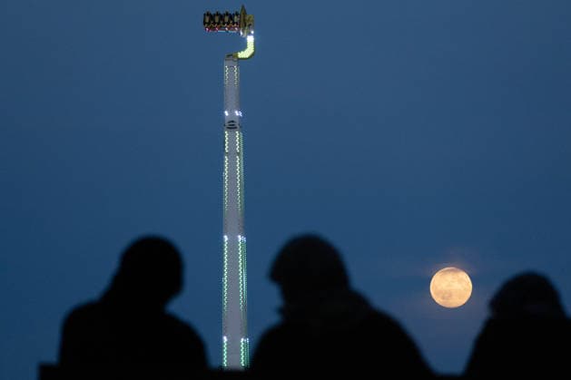 September 26, 2026, Frankfurt, Hesse, Germany: The September full moon, known as the Harvest Moon, rises behind people during an autumn fun fair in Frankfurt am Main, Germany. Frankfurt Germany - ZUMAb332 20260926_zip_b332_006 Copyright: xMatiasxBasualdox