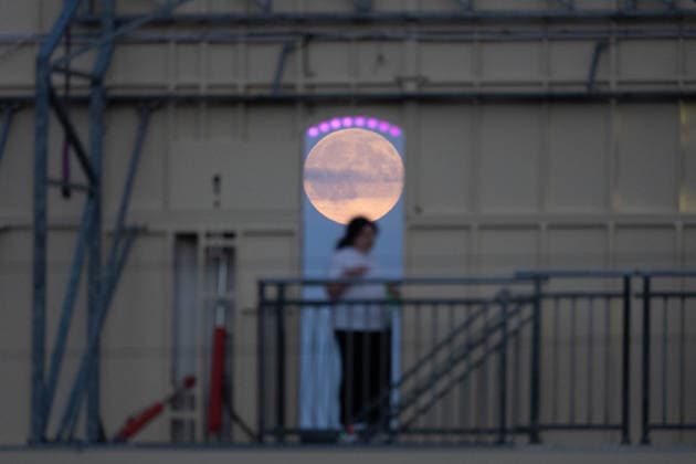 September 26, 2026, Frankfurt, Hesse, Germany: The September full moon, known as the Harvest Moon, rises behind a person and through the structure of an amusement ride during an autumn fun fair in Frankfurt am Main, Germany. Frankfurt Germany - ZUMAb332 20260926_zip_b332_002 Copyright: xMatiasxBasualdox