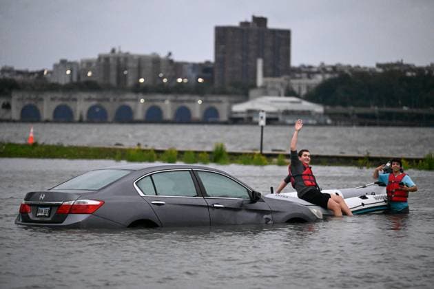 September 26, 2026, Edgewater, New Jersey, USA: A man on a boat waves as another man on the boat looks on as a vehicle is seen submerged in flood waters in the parking lot of the Comfort Inn Edgewater on Hudson River during a nor easter storm in Edgewater, New Jersey, United States on Saturday, Sept. 26, 2026. Heavy rain and strong winds battered the northeastern United States as an unusually powerful autumn storm intensified, forcing the cancelation of hundreds of flights and leaving tens of thousands of people without power. New York, Boston and Philadelphia were all in the crosshairs of the Nor easter -- so labeled for its northeasterly winds -- as authorities warned of potential major flooding and road closures. Edgewater USA - ZUMAs197 20260926_aaa_s197_288 Copyright: xKylexMazzax