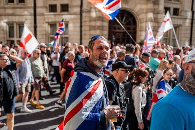 September 26, 2026, London, United Kingdom: An anti-migrant protestor wears a Union Jack flag across his shoulders during a protest against grooming gangs targeting British girls. The event organised by Together For The Children in collaboration with Football Lads on National Survivors Day stands in solidarity with survivors of child sexual abuse and sexual violence while demanding stronger child protections and legal reforms, as well as a curb on illegal migration. London United Kingdom - ZUMAs197 20260926_aaa_s197_327 Copyright: xLabxMox