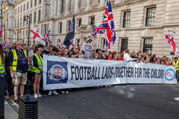 September 26, 2026, London, United Kingdom: Anti-migrant protestors hold a banner during a protest against grooming gangs targeting British girls. The event organised by Together For The Children in collaboration with Football Lads on National Survivors Day stands in solidarity with survivors of child sexual abuse and sexual violence while demanding stronger child protections and legal reforms, as well as a curb on illegal migration. London United Kingdom - ZUMAs197 20260926_aaa_s197_302 Copyright: xLabxMox
