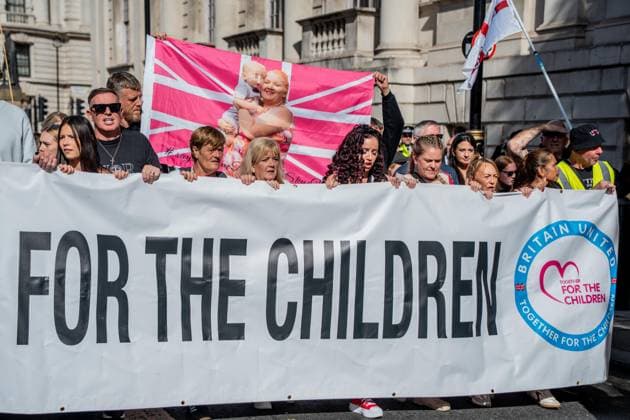 September 26, 2026, London, United Kingdom: Anti-migrant protestors hold a banner during a protest against grooming gangs targeting British girls. The event organised by Together For The Children in collaboration with Football Lads on National Survivors Day stands in solidarity with survivors of child sexual abuse and sexual violence while demanding stronger child protections and legal reforms, as well as a curb on illegal migration. London United Kingdom - ZUMAs197 20260926_aaa_s197_303 Copyright: xLabxMox