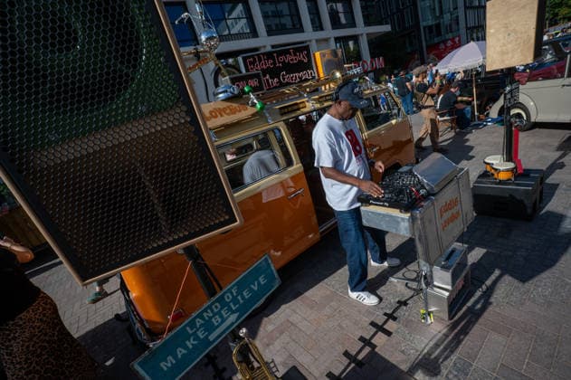September 26, 2026, London, United Kingdom: A DJ entertains visitors during the King™s Cross Classic Car Boot Sale, held at Granary Square in King™s Cross, London. The Kings Cross Classic Car Boot Sale returned to Granary Square and Stable Street, King™s Cross, London, for its 11th year. Held several times throughout the year, the event brings together vintage fashion, second-hand clothing, jewellery, homewares, collectables and vinyl records alongside classic cars, motorcycles and commercial vehicles. Visitors browsed stalls and traders, with many making a special effort to dress in period clothing inspired by the 1950s, 1960s and 1970s.continuing a tradition associated with the event. London United Kingdom - ZUMAs197 20260926_aaa_s197_394 Copyright: xJamesxWilloughbyx
