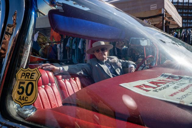 September 26, 2026, London, United Kingdom: Soho George, also known as George Skeggs, poses for photographs while sitting in a 1950s red Cadillac. The Kings Cross Classic Car Boot Sale returned to Granary Square and Stable Street, King™s Cross, London, for its 11th year. Held several times throughout the year, the event brings together vintage fashion, second-hand clothing, jewellery, homewares, collectables and vinyl records alongside classic cars, motorcycles and commercial vehicles. Visitors browsed stalls and traders, with many making a special effort to dress in period clothing inspired by the 1950s, 1960s and 1970s.continuing a tradition associated with the event. London United Kingdom - ZUMAs197 20260926_aaa_s197_387 Copyright: xJamesxWilloughbyx
