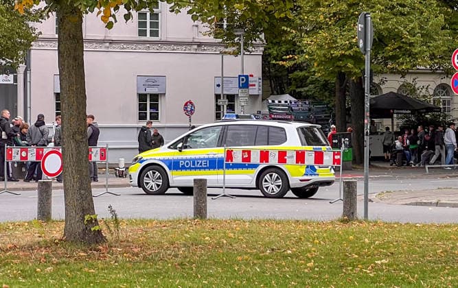 Hanover, Lower Saxony, Germany, Europe A police vehicle is parked in front of a group of soccer fans near an event; barriers, spectators, and fan merchandise are visible in the background. Stock image depicting a police operation, security measures, soccer, fans, public order, and large-scale events Copyright: xAymanxAlahmedx