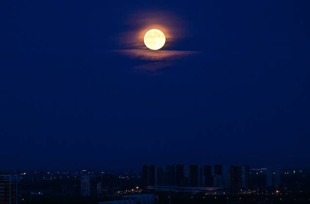 BEIJING, CHINA - SEPTEMBER 27: A full moon rises above city buildings on September 27, 2026 in Beijing, China. The moon reached its fullest phase on the 17th day of the lunar month, two days after the Mid-Autumn Festival.  Copyright: xVCGx 111669994814