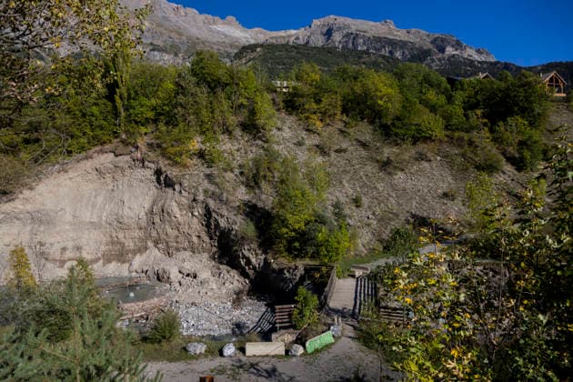Gyr Flood Damage - France A broad landslide overlooks a footbridge, while houses remain visible above the unstable slope. Vallouise-Pelvoux, Hautes-Alpes, France, September 27, 2026. The exceptional floods of August 28 caused major damage in Vallouise-Pelvoux and on the road to Ailefroide. The damage highlights the growing exposure of Alpine valleys to intense rainfall and torrential hazards in a warming climate. Photo by Thibaut Durand ABACAPRESS.COM Vallouise-Pelvoux PROVENCE-ALPES-COTE D AZUR France  Copyright: xDurandxThibaut ABACAx