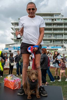 Terrier Derby at Epsom Racecourse in Surrey - 27 Sep 2026 The winner of the 2026 Terrier Derby, Barney, and his owner Karl Thorpe hold up the Smudge Cup after winning the race at Epsom Racecourse. Terriers competed in the annual Terrier Derby held at Epsom Racecourse, Surrey, an event first held in 2003 as a side attraction to Epsom Trainers Day. More than 70 dogs took part in heats, quarter-finals and semi-finals before the grand finale, chasing a mechanically towed lure along a racetrack. The event was inspired by Jack Russell terrier Smudge and raises money for charity, with spectators also attending a dog show, raffle, trade stalls and other attractions. Epsom United Kingdom Copyright: xJamesxWilloughbyx xSOPAxImagesx JWILLOUGHBY_3527