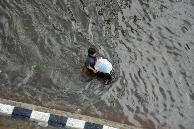 Severe floods in Bang Kapi District, Bangkok - 28 Sept 2026 A view from above of a young man carrying a plastic box with a plastic bag of food on top, walking through the floodwater on Lat Phrao Road in Bang Kapi District. On September 26, all 50 districts of Bangkok were declared disaster-affected areas. Three days later, floodwaters still remained in parts of the city. In heavily affected areas such as Bang Kapi District, residents remained in floodwater. Bangkok Thailand Copyright: xNathaliexJamoisx xSOPAxImagesx NathalieJamois_BangKapiFlood2026-8