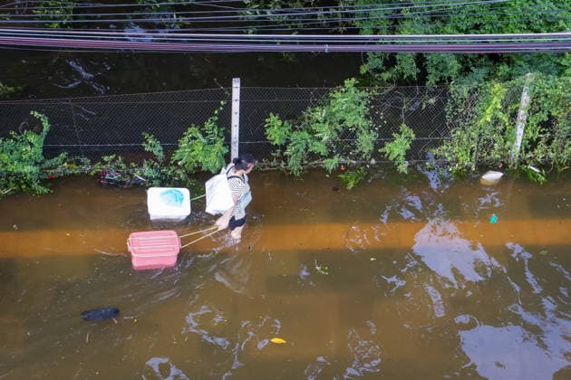September 28, 2026, Bangkok, Thailand: A view from above of a woman dragging two plastic containers behind her through the muddy floodwater on Lat Phrao Road in Bang Kapi District. On September 26, all 50 districts of Bangkok were declared disaster-affected areas. Three days later, floodwaters still remained in parts of the city. In heavily affected areas such as Bang Kapi District, residents remained in floodwater. Bangkok Thailand  - ZUMAs197 20260928_aaa_s197_371 Copyright: xNathaliexJamoisx