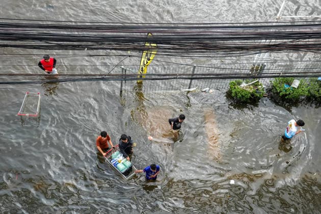 September 28, 2026, Bangkok, Thailand: A view from above of young men pushing a shopping cart through the floodwater on Lat Phrao Road in Bang Kapi District. On September 26, all 50 districts of Bangkok were declared disaster-affected areas. Three days later, floodwaters still remained in parts of the city. In heavily affected areas such as Bang Kapi District, residents remained in floodwater. Bangkok Thailand - ZUMAs197 20260928_aaa_s197_355 Copyright: xNathaliexJamoisx