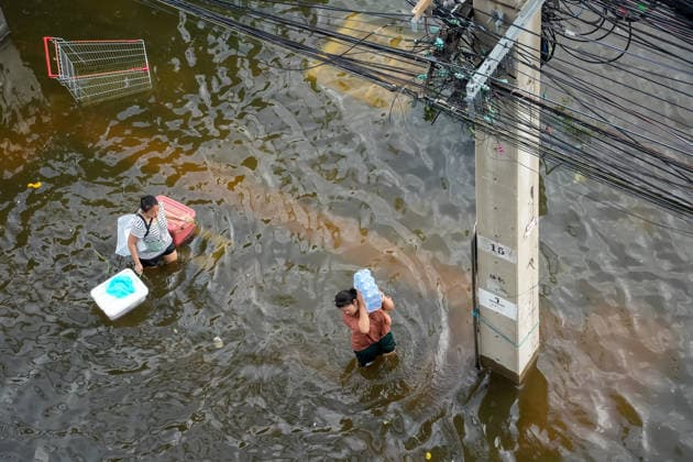September 28, 2026, Bangkok, Thailand: A view from above of two women carrying bags and water while walking through the floodwater on Lat Phrao Road in Bangkok. On September 26, all 50 districts of Bangkok were declared disaster-affected areas. Three days later, floodwaters still remained in parts of the city. In heavily affected areas such as Bang Kapi District, residents remained in floodwater. Bangkok Thailand - ZUMAs197 20260928_aaa_s197_360 Copyright: xNathaliexJamoisx