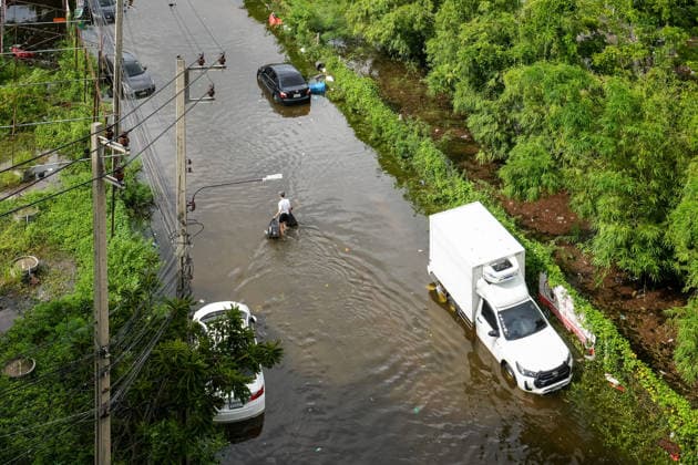 September 28, 2026, Bangkok, Thailand: A view from above of a man carrying bags, walking through the floodwater surrounded by abandoned cars in Bang Kapi District. On September 26, all 50 districts of Bangkok were declared disaster-affected areas. Three days later, floodwaters still remained in parts of the city. In heavily affected areas such as Bang Kapi District, residents remained in floodwater. Bangkok Thailand - ZUMAs197 20260928_aaa_s197_362 Copyright: xNathaliexJamoisx