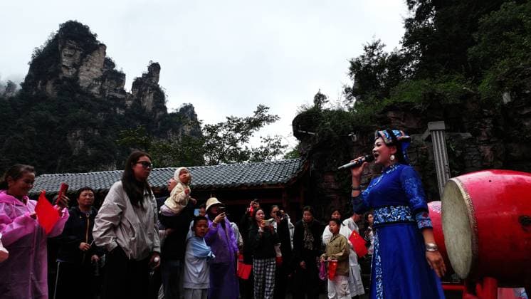 ZHANGJIAJIE, CHINA - OCTOBER 01: Tourists gather to celebrate the 77th anniversary of the founding of the People s Republic of China with colorful activities including welcome drums, door-blocking wine, hand-waving dances, cake tasting and folk songs at Bailong Elevator viewing platform in Zhangjiajie National Forest Park on October 1, 2026 in Zhangjiajie, Hunan Province of China. Copyright: xVCGx 111670911313