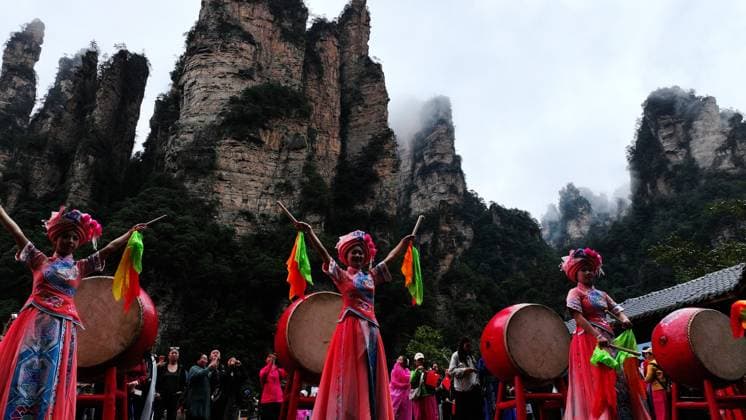 ZHANGJIAJIE, CHINA - OCTOBER 01: Tourists gather to celebrate the 77th anniversary of the founding of the People s Republic of China amid colorful activities including welcome drums, blocking-door wine, hand-waving dances, cake tasting and folk songs at Bailong Elevator viewing platform in Zhangjiajie National Forest Park on October 1, 2026 in Zhangjiajie, Hunan Province of China. Various events were held across the scenic area to attract domestic and international visitors during the National Day holiday. Copyright: xVCGx 111670911315