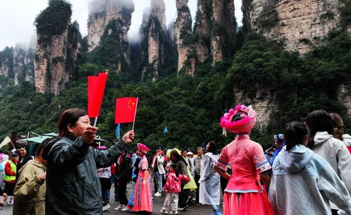 ZHANGJIAJIE, CHINA - OCTOBER 01: Tourists gather to celebrate the 77th anniversary of the founding of the People s Republic of China with colorful activities including welcome drums, blocking-door wine, hand-waving dances, cake tasting and folk singing at Bailong Elevator viewing platform in Zhangjiajie National Forest Park on October 1, 2026 in Zhangjiajie, Hunan Province of China. Copyright: xVCGx 111670911319