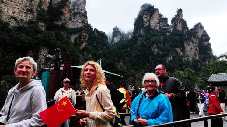 ZHANGJIAJIE, CHINA - OCTOBER 01: Tourists gather to celebrate the 77th anniversary of the founding of the People s Republic of China with colorful activities including welcome drums, door-blocking wine, hand-waving dance, cake tasting and folk singing at Bailong Elevator viewing platform in Zhangjiajie National Forest Park on October 1, 2026 in Zhangjiajie, Hunan Province of China. Copyright: xVCGx 111670911307