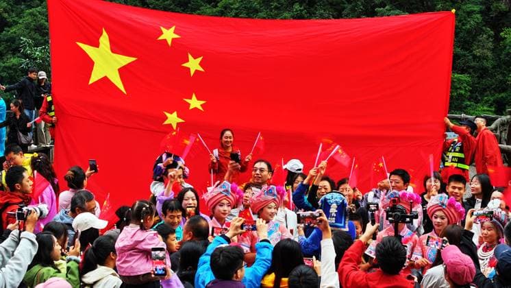 ZHANGJIAJIE, CHINA - OCTOBER 01: Tourists gather to celebrate the 77th anniversary of the founding of the People s Republic of China with colorful activities including welcome drums, blocking-door wine, hand-waving dance, cake tasting and folk singing at Bailong Elevator viewing platform in Zhangjiajie National Forest Park on October 1, 2026 in Zhangjiajie, Hunan Province of China. The event was held to mark the National Day holiday. Copyright: xVCGx 111670911300