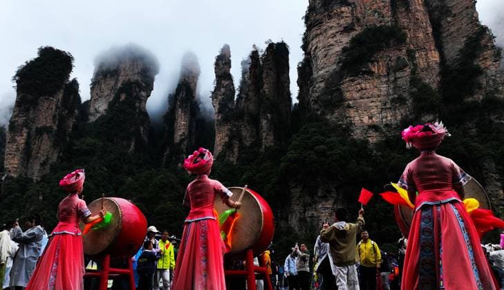 ZHANGJIAJIE, CHINA - OCTOBER 01: Tourists gather to celebrate the 77th anniversary of the founding of the People s Republic of China during colorful activities including drum performances, welcoming wine ceremonies, traditional dances, cake tasting and folk singing at Bailong Elevator viewing platform in Zhangjiajie National Forest Park on October 1, 2026 in Zhangjiajie, Hunan Province of China. The event attracted numerous domestic and international visitors during the National Day holiday. Copyright: xVCGx 111670911292