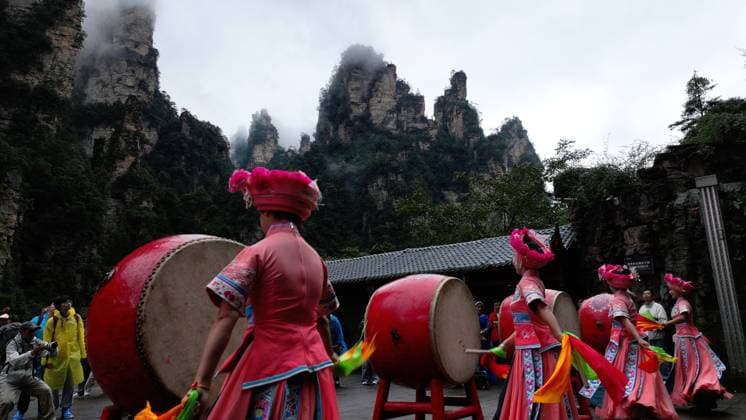 ZHANGJIAJIE, CHINA - OCTOBER 01: Tourists gather to celebrate the 77th anniversary of the founding of the People s Republic of China with activities including welcome drums, door-blocking wine, hand-waving dances, cake tasting and folk singing at Bailong Elevator viewing platform in Zhangjiajie National Forest Park on October 1, 2026 in Zhangjiajie, Hunan Province of China. Various events were held across scenic spots to attract visitors during the National Day holiday. Copyright: xVCGx 111670911293