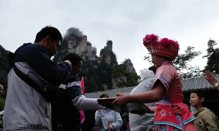ZHANGJIAJIE, CHINA - OCTOBER 01: Tourists gather to celebrate the 77th anniversary of the founding of the People s Republic of China with colorful activities including welcome drums, blocking-door wine, hand-waving dances, cake tasting and folk songs at Bailong Elevator viewing platform in Zhangjiajie National Forest Park on October 1, 2026 in Zhangjiajie, Hunan Province of China. Copyright: xVCGx 111670911298