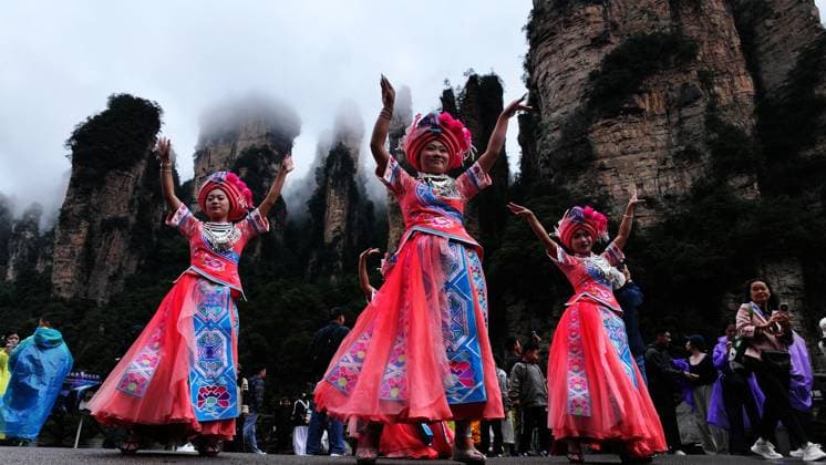 ZHANGJIAJIE, CHINA - OCTOBER 01: Tourists gather to celebrate the 77th anniversary of the founding of the People s Republic of China with colorful activities including welcome drums, blocking-door wine, hand-waving dance, cake tasting and folk singing at Bailong Elevator viewing platform in Zhangjiajie National Forest Park on October 1, 2026 in Zhangjiajie, Hunan Province of China. Copyright: xVCGx 111670911286