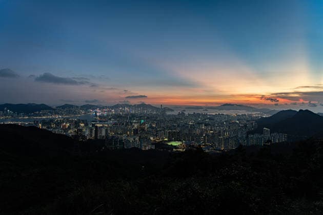 HONG KONG-DAILY NATIONAL-DAY A panoramic general view captured from Kowloon Peak (Fei Ngo Shan) shows the sun setting over the Kowloon Peninsula and Victoria Harbour ahead of the National Day evening celebrations on October 1, 2026 in Hong Kong, casting a golden glow across the urban cityscape and harbour skyline. (Photo by Kevin Li TMHK via Nexpher Images) Hong Kong