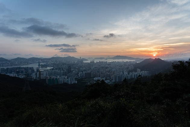 HONG KONG-DAILY NATIONAL-DAY A panoramic general view captured from Kowloon Peak (Fei Ngo Shan) shows the sun setting over the Kowloon Peninsula and Victoria Harbour ahead of the National Day evening celebrations on October 1, 2026 in Hong Kong, casting a golden glow across the urban cityscape and harbour skyline. (Photo by Kevin Li TMHK via Nexpher Images) Hong Kong