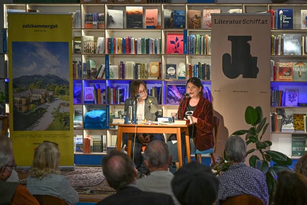 Minifestival AH0J (Literaturfestival) - Tschechien setzt über - der Kulturinitiative Literaturschiff, in der Buchhandlung Kurdirektion in Bad Ischl. Lesungen und Gespräche in Korrespondenz zum Gastauftritt Tschechiens auf der Frankfurter Buchmesse 2026. Es liest die tschechische Schriftstellerin und mehrfache Literaturpreisträgerin Radka Denemarkovich. Die Veranstaltung wird moderiert von Julia Miesenböck, fotografiert am 30.09.26. Das Bild zeigt links die Moderatorin Julia Miesenböck mit der Schriftstellerin Radka Denemarkovic im Gespräch vor Publikum 2026 - Minifestival AH0J (Literaturfestival) - Tschechien setzt über - der Kulturinitiative Literaturschiff, in der Buchhandlung Kurdirektion in Bad Ischl. Lesungen und Gespräche in K