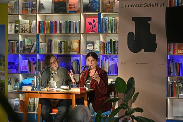 Minifestival AH0J (Literaturfestival) - Tschechien setzt über - der Kulturinitiative Literaturschiff, in der Buchhandlung Kurdirektion in Bad Ischl. Lesungen und Gespräche in Korrespondenz zum Gastauftritt Tschechiens auf der Frankfurter Buchmesse 2026. Es liest die tschechische Schriftstellerin und mehrfache Literaturpreisträgerin Radka Denemarkovich. Die Veranstaltung wird moderiert von Julia Miesenböck, fotografiert am 30.09.26. Das Bild zeigt links die Moderatorin Julia Miesenböck mit der Schriftstellerin Radka Denemarkovic im Gespräch vor Publikum 2026 - Minifestival AH0J (Literaturfestival) - Tschechien setzt über - der Kulturinitiative Literaturschiff, in der Buchhandlung Kurdirektion in Bad Ischl. Lesungen und Gespräche in K