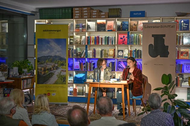 Minifestival AH0J (Literaturfestival) - Tschechien setzt über - der Kulturinitiative Literaturschiff, in der Buchhandlung Kurdirektion in Bad Ischl. Lesungen und Gespräche in Korrespondenz zum Gastauftritt Tschechiens auf der Frankfurter Buchmesse 2026. Es liest die tschechische Schriftstellerin und mehrfache Literaturpreisträgerin Radka Denemarkovich. Die Veranstaltung wird moderiert von Julia Miesenböck, fotografiert am 30.09.26. Das Bild zeigt links die Moderatorin Julia Miesenböck mit der Schriftstellerin Radka Denemarkovic im Gespräch vor Publikum 2026 - Minifestival AH0J (Literaturfestival) - Tschechien setzt über - der Kulturinitiative Literaturschiff, in der Buchhandlung Kurdirektion in Bad Ischl. Lesungen und Gespräche in K