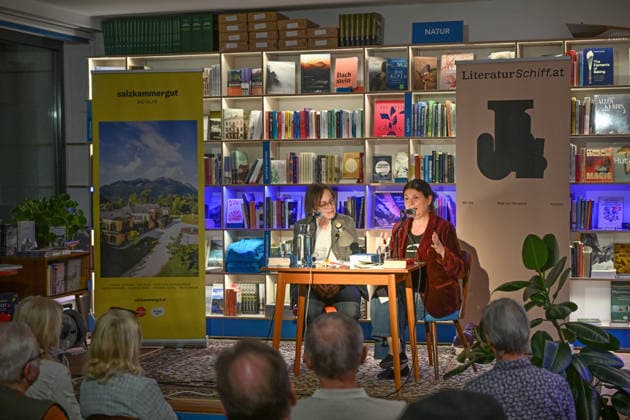 Minifestival AH0J (Literaturfestival) - Tschechien setzt über - der Kulturinitiative Literaturschiff, in der Buchhandlung Kurdirektion in Bad Ischl. Lesungen und Gespräche in Korrespondenz zum Gastauftritt Tschechiens auf der Frankfurter Buchmesse 2026. Es liest die tschechische Schriftstellerin und mehrfache Literaturpreisträgerin Radka Denemarkovich. Die Veranstaltung wird moderiert von Julia Miesenböck, fotografiert am 30.09.26. Das Bild zeigt links die Moderatorin Julia Miesenböck mit der Schriftstellerin Radka Denemarkovic im Gespräch vor Publikum 2026 - Minifestival AH0J (Literaturfestival) - Tschechien setzt über - der Kulturinitiative Literaturschiff, in der Buchhandlung Kurdirektion in Bad Ischl. Lesungen und Gespräche in K