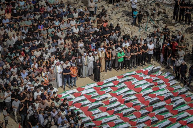 Gaza Funeral For Recovered Victims An elevated view shows hundreds of mourners gathered around rows of Palestinian flag-draped shrouds amid rubble in Gaza City, Gaza Strip, on October 1, 2026. Gaza Civil Defense said the remains were among those of 105 Palestinians recovered during a 17-day search of the Al-Taj residential block in the Al-Yarmouk area, which was struck by Israel on October 25, 2023. Gaza City Gaza Strip Palestinian Territories Copyright: xMohammedxMxSkaikx