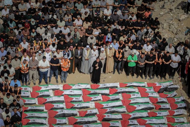 Gaza Funeral For Recovered Victims An elevated view shows mourners standing shoulder to shoulder behind rows of Palestinian flag-draped shrouds during funeral proceedings in Gaza City, Gaza Strip, on October 1, 2026. Gaza Civil Defense said the remains were among those of 105 Palestinians recovered during a 17-day search of the Al-Taj residential block in the Al-Yarmouk area, which was struck by Israel on October 25, 2023. Gaza City Gaza Strip Palestinian Territories Copyright: xMohammedxMxSkaikx