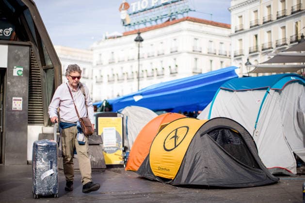 Fifth day of the housing protest camp in Madrid, Spain - 01 Oct 2026 A tourist with a suitcase leaves the Sol metro station while protesters tents viewed nearby at Puerta del Sol square in central Madrid, during a protest camp against the high cost of housing and rent. The protest arose following the eviction of an 87-years-old woman from her apartment in Madrid. Madrid Spain Copyright: xLuisxSotox xSOPAxImagesx LSOTOQDA02