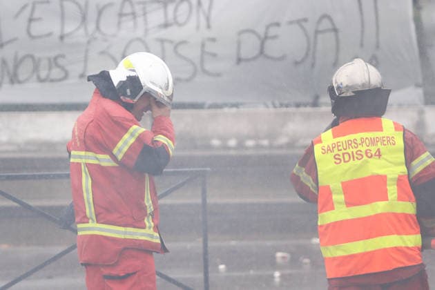 October 1, 2026, Anglet, Nouvelle Aquitaine, France: A firefighter rubs his eyes, irritated by smoke, as a colleague holds a hose during a protest outside the Lyco e Cantau in Anglet, southwestern France, on October 1, 2026, against overcrowded classes and a lack of resources. The movement, which began in the Paris region a week ago, has spread across France, with hundreds of high schools blocked. Anglet France - ZUMAb298 20261001_zsp_b298_028 Copyright: xJulesxBuonx