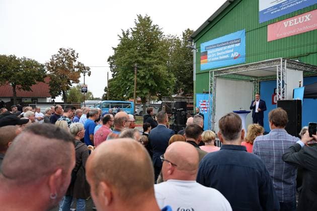 Enjoying a Bratwurst with Haseloff and Chrupalla, October 1, 2026, Doellstaedt, AfD event at Kiesling Roofing; enjoying a bratwurst with State Parliament Representative Daniel Haseloff (AfD) and AfD National Spokesperson Tino Chrupalla; pictured: Tino Chrupalla giving a speech on stage, with event attendees standing around the stage