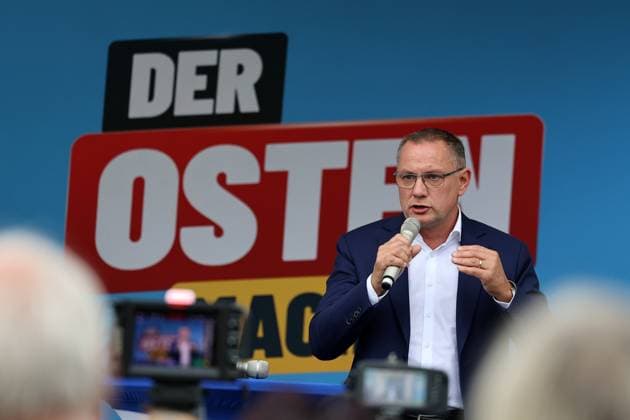 Enjoying a Bratwurst with Haseloff and Chrupalla, October 1, 2026, Doellstaedt, AfD event at Kiesling Roofing, Enjoying a bratwurst with State Parliament Representative Daniel Haseloff (AfD) and AfD National Spokesperson Tino Chrupalla. Pictured: Tino Chrupalla giving a speech on stage; in the background is the phrase The East is doing it.