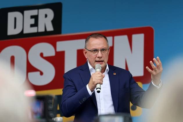 Enjoying a Bratwurst with Haseloff and Chrupalla, October 1, 2026, Doellstaedt, AfD event at Kiesling Roofing, Enjoying a bratwurst with State Parliament Representative Daniel Haseloff (AfD) and AfD National Spokesperson Tino Chrupalla; pictured: Tino Chrupalla giving a speech on stage, with the phrase The East is doing it visible in the background