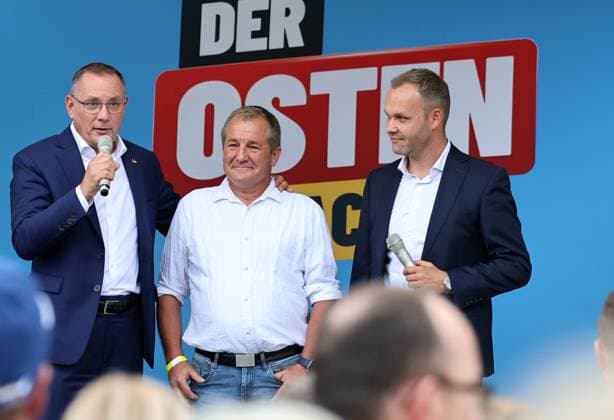 Over a bratwurst with Haseloff and Chrupalla, October 1, 2026, Doellstaedt, AfD event at Kiesling Roofing, Enjoying a bratwurst with State Parliament Member Daniel Haseloff (AfD) and AfD National Spokesperson Tino Chrupalla; pictured: Tino Chrupalla with Mark Kiesling, owner of Kiesling Roofing, and Daniel Haseloff (AfD) on stage; in the background i