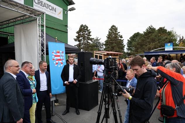Enjoying a bratwurst with Haseloff and Chrupalla on October 1, 2026, in Doellstaedt, at an AfD event held at Kiesling Roofing; pictured are AfD state parliament member Daniel Haseloff and AfD national spokesperson Tino Chrupalla, along with Marcus Buehl, a member